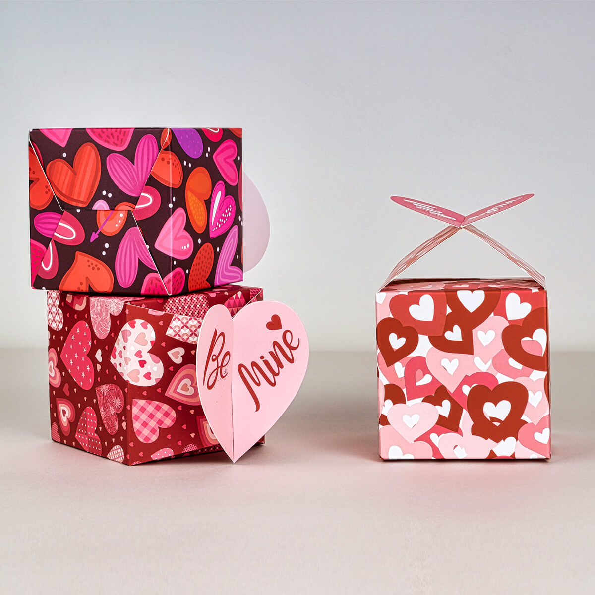 Three custom folding boxes featuring lids that can be folded into heart shapes for decorative packaging