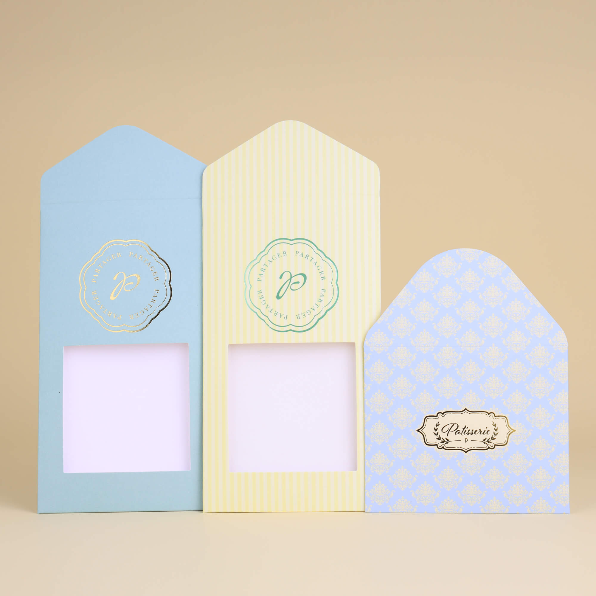 Set of three envelope-style paper bags, two featuring central windows for product display